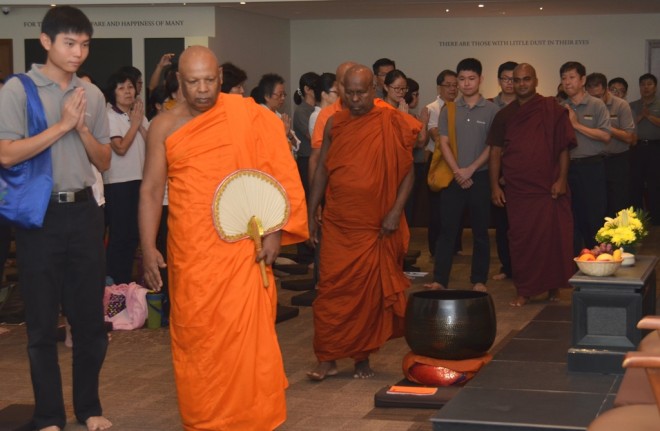 Four venerable monks arriving in the hall for the auspicious ceremony.