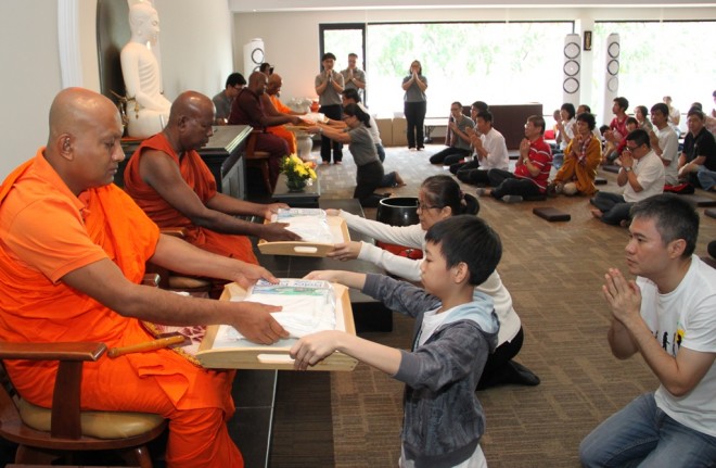 A young family came together to make offerings to the monks.