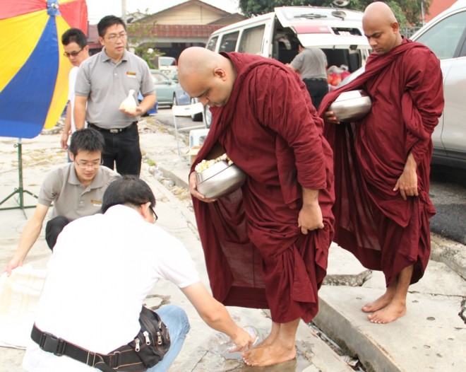 Nalandians and devotees helping the venerables to wash their feet after alms-round.