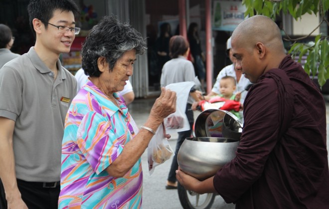 Devotees offering alms to venerable bhikkhus.