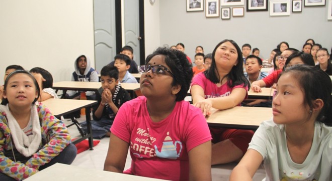 Bright-eyed students listening attentively to their teacher in their first lesson. 