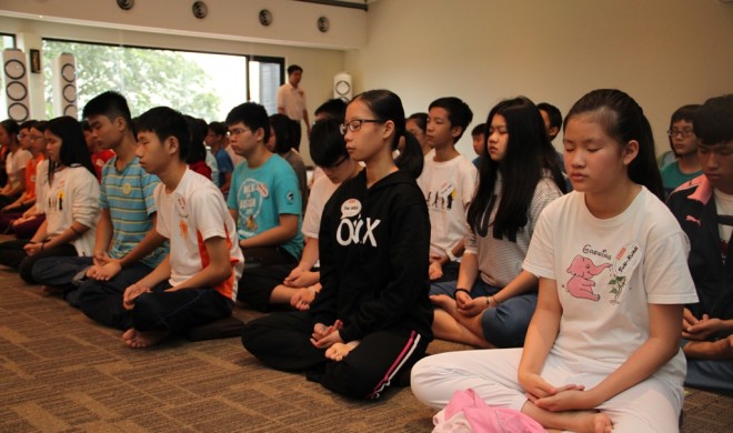 Teenagers learning to calm their minds with meditation.