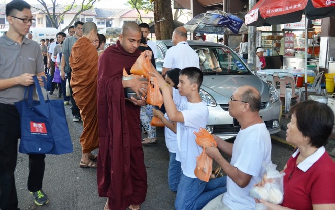Venerables receiving offerings from devotees.