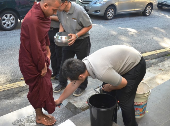 A Nalandian helping Ven. Sumanaransi to wash his feet after the alms-round.