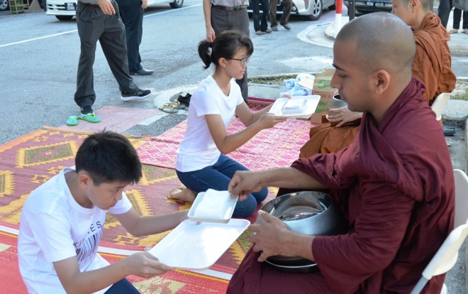 Young devotees offering the venerables wet towels to refresh themselves.