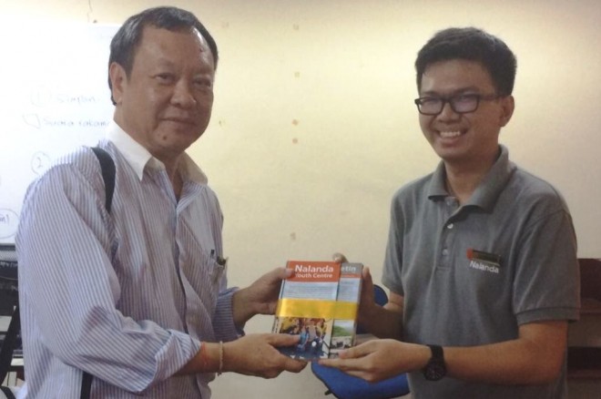 Bro. Jie Sheng presenting Nalanda publications to Bro. Johnny.