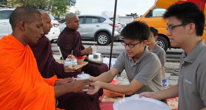 Youths offering the venerables a drink to quench their thirst after the alms-round.