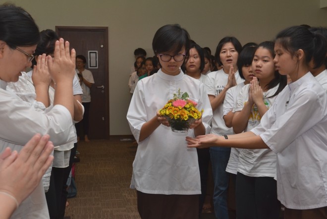 Offering of flowers to the 'Three Jewels'.