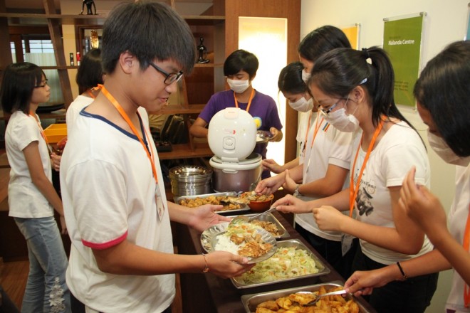 Camp participants learn the importance of teamwork and responsibility through simple chores such as serving their fellow participants during meal times.
