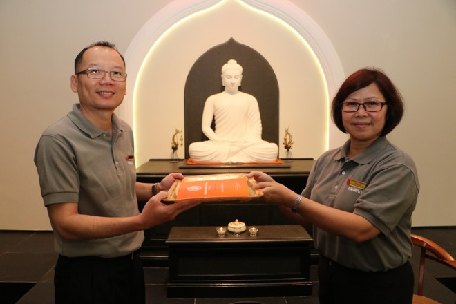 Sis. Evelyn handing a copy of Nalanda Constitution to KL Branch Chairman Bro. Ng.