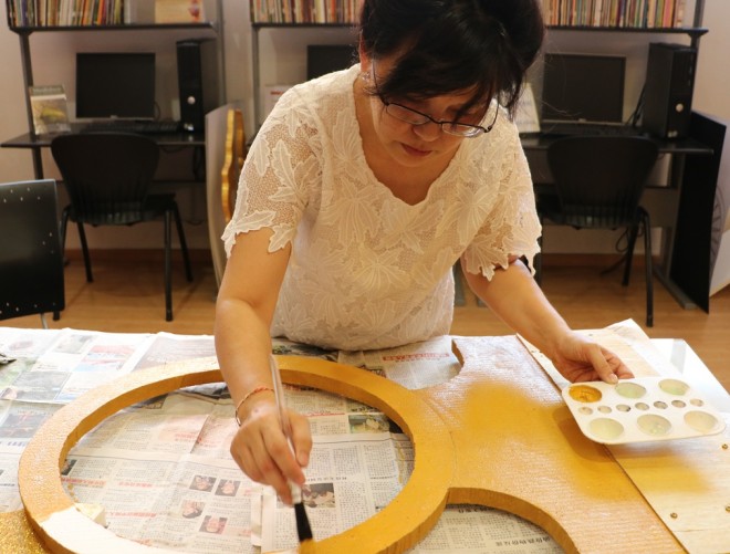 Sis. Sujata giving the finishing touches on a decoration for the Buddha Day Heritage procession 