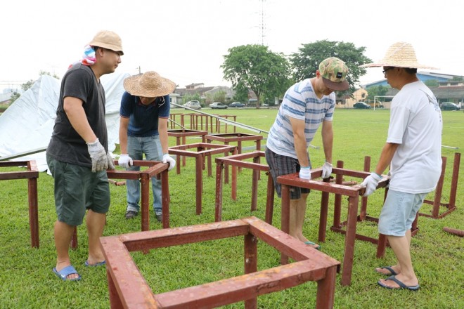 Volunteers working together harmoniously to prepare the venue for Wesak Day.