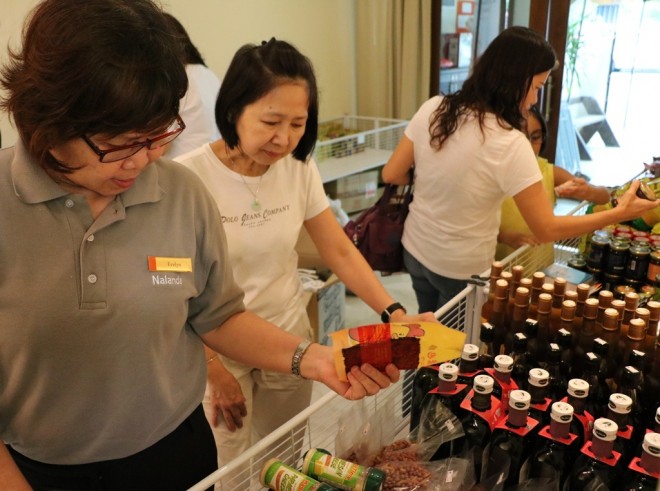 Organising team members Sis. Evelyn and Mrs. Ng checking on the food items on pre-sales.