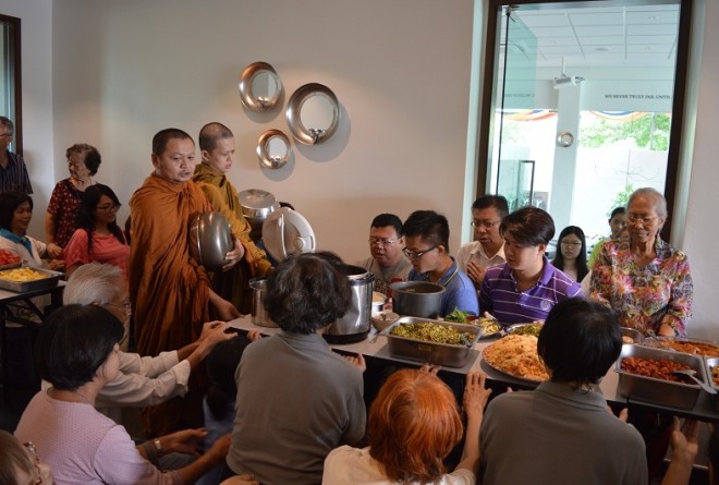 Ven. Thipako and Ven. Foo accepting devotees' offering of lunch dāna.