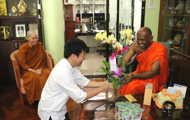 Bro. Tan presenting flowers to Ven. Saranankara on behalf of Nalandians.