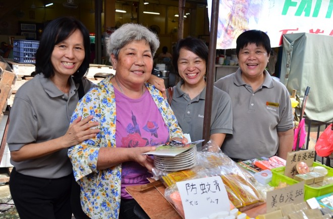 Nalandians posing with a stall-owner at the market.