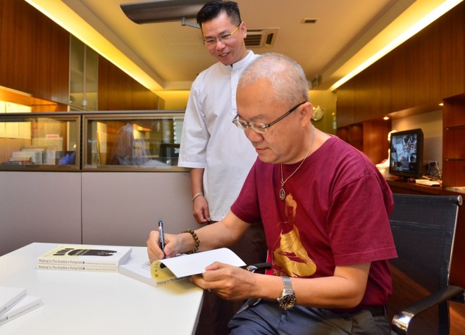 Dr. Wong autographing a few copies of his book for Nalanda Library.