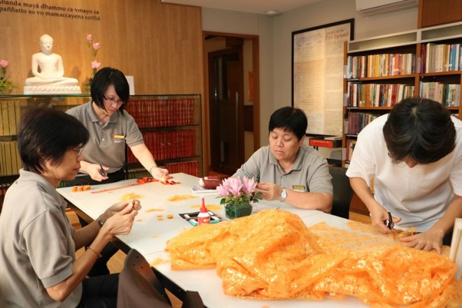 Nalanda members taking turns to prepare the robes.