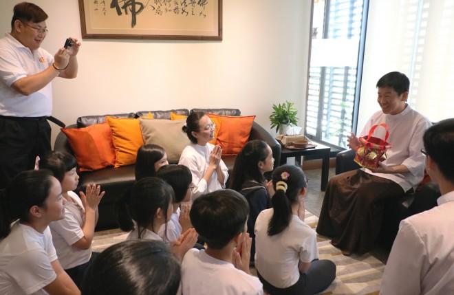Junior Dhamma School Facilitators and students presenting a lovely hand-made basket with cookies to Bro Tan.
