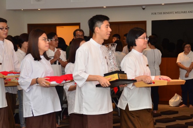 School Facilitators follow the procession bearing the Dhammavijaya Challenge Trophy, medals and certificates.