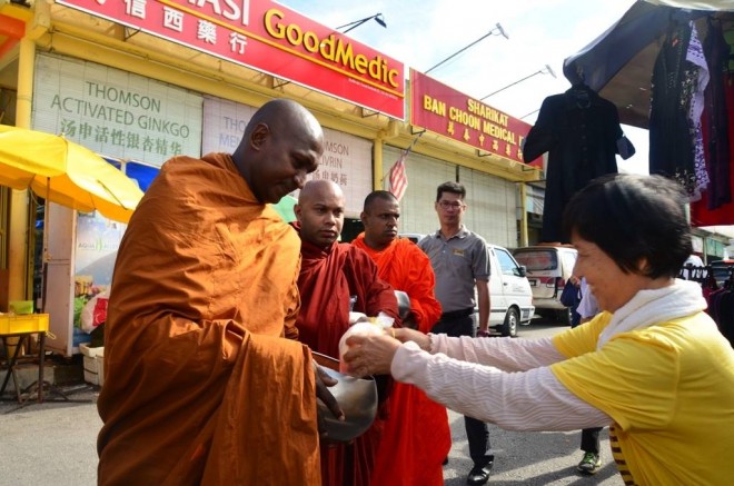 Stall-operators and market-goers offer food respectfully and joyfully on every alms-round.