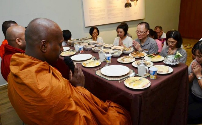 Offering the noon meal to the venerable monks after their alms-round.